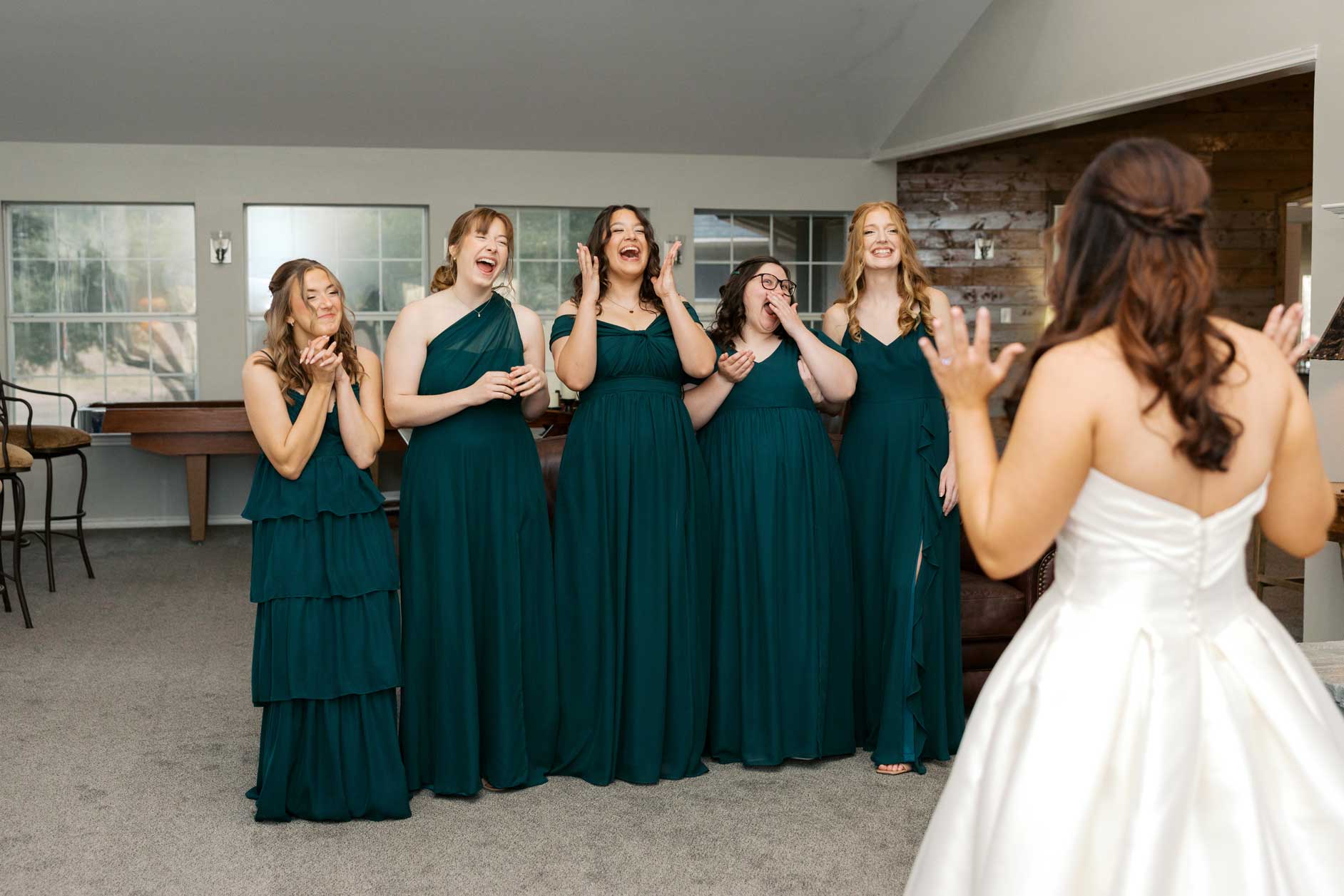 Bride sharing a first look moment with bridesmaids in a bridal suite at Willowood Ranch wedding venue in North Texas