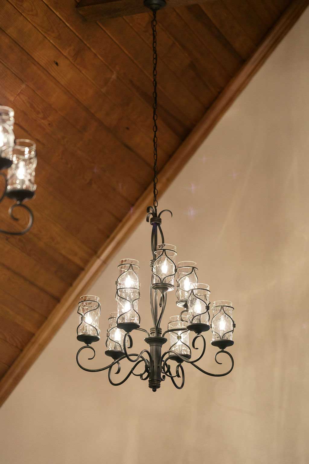 Chandelier lighting inside Willowood Ranch chapel with wood ceiling and warm ambient glow