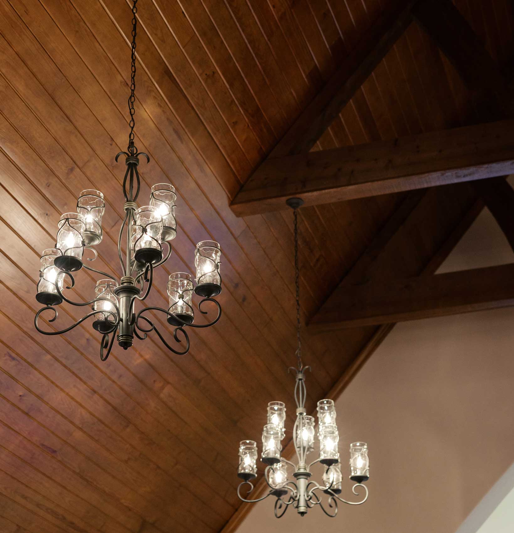 Chandeliers hanging from wooden ceiling inside Willowood Ranch wedding chapel in Bells Texas