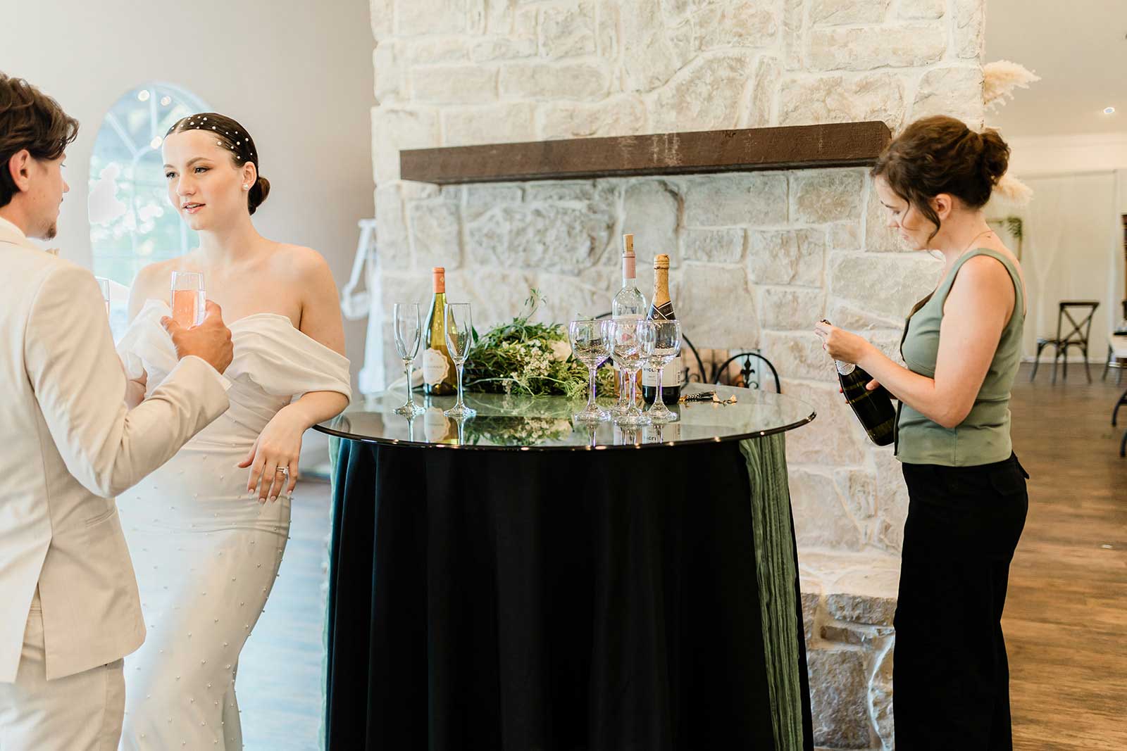 Wedding guests enjoying cocktail hour inside the Willowood Ranch event center in Texas with drinks and conversation