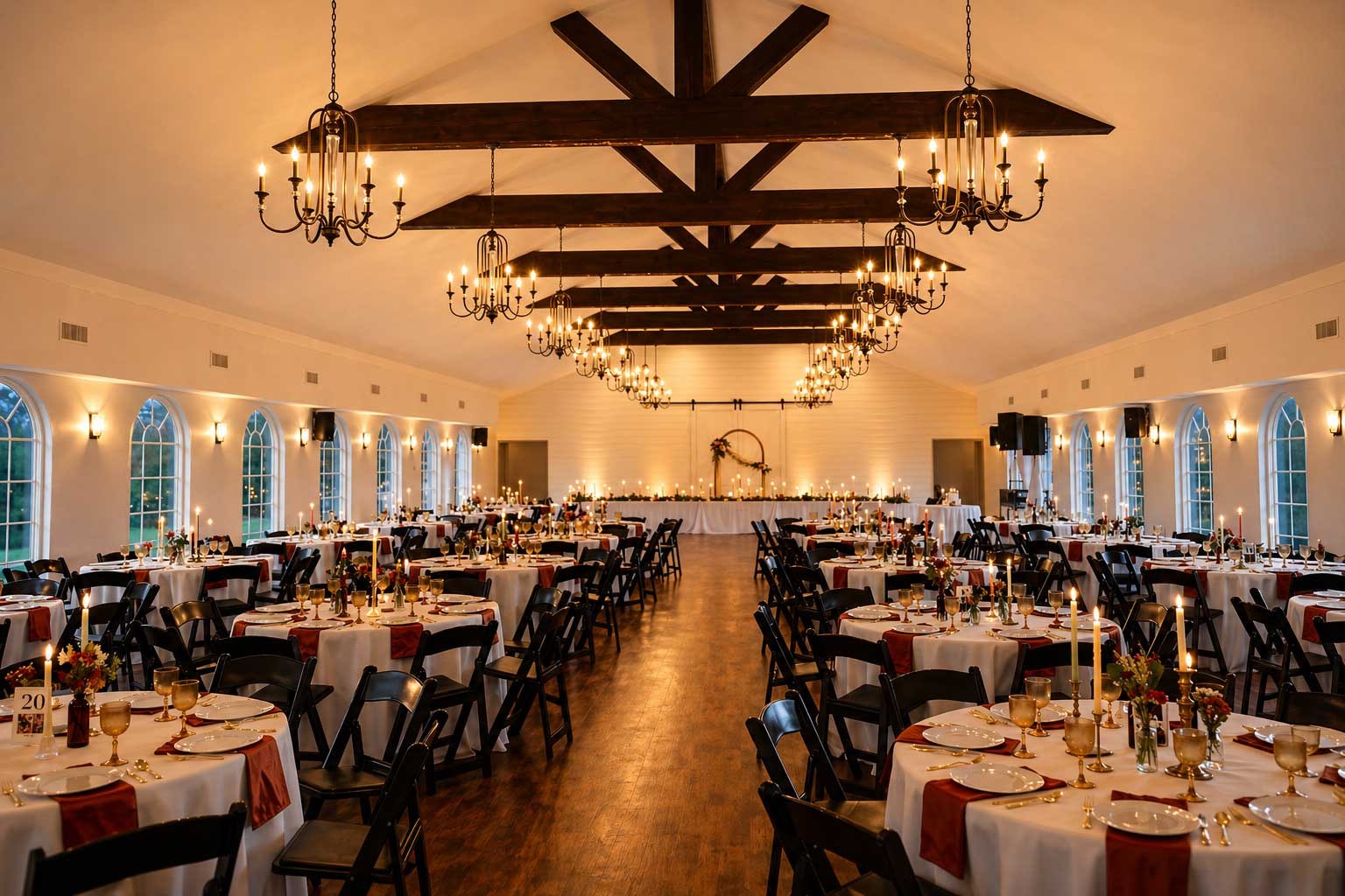 Wedding reception setup inside Willowood Ranch Event Center with round tables, chandeliers, and seating for guests near Dallas, Texas