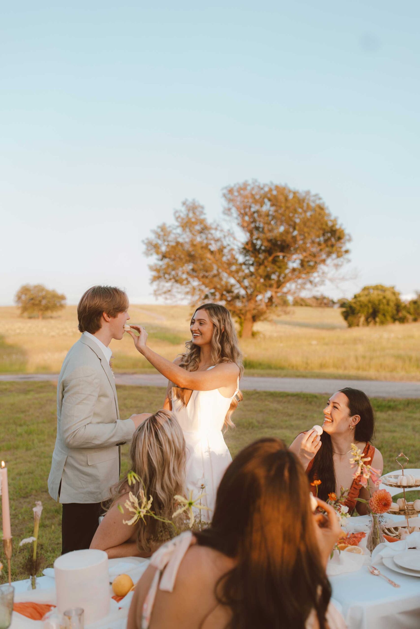 Bride and groom enjoying golden hour with guests during an outdoor wedding reception at Willowood Ranch in Texas