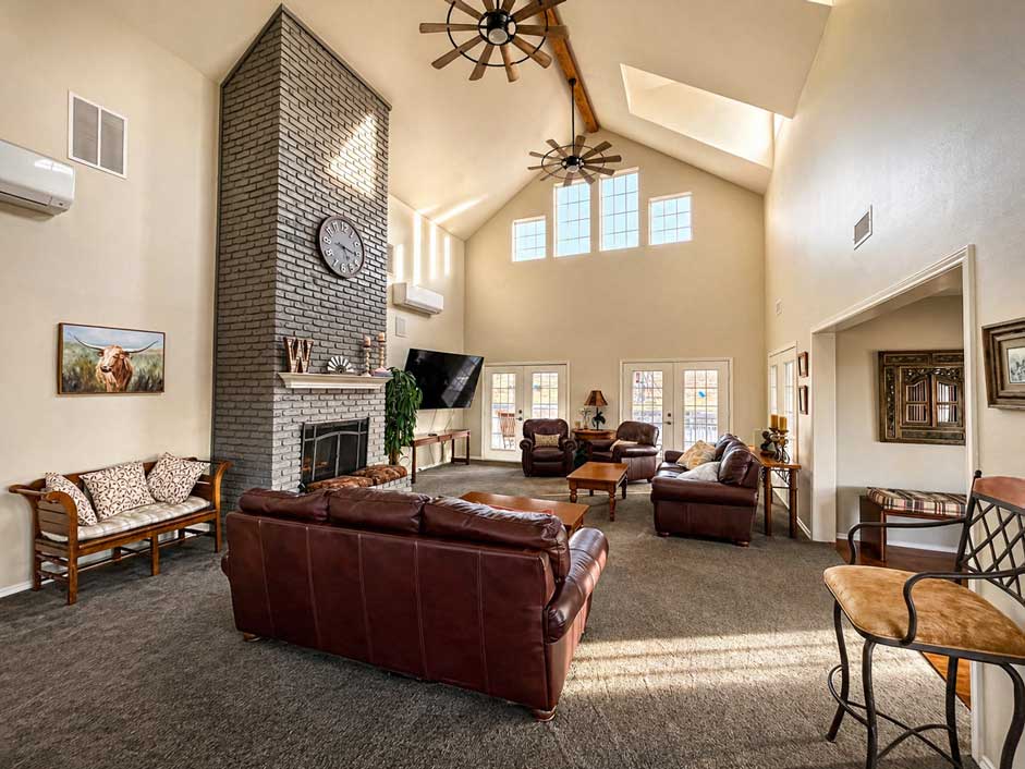 Spacious grand room inside Willowood Ranch main house with vaulted ceilings, fireplace, and seating for wedding guests