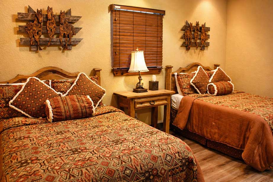 Guest bedroom at Willowood Ranch lodge with two beds and rustic decor