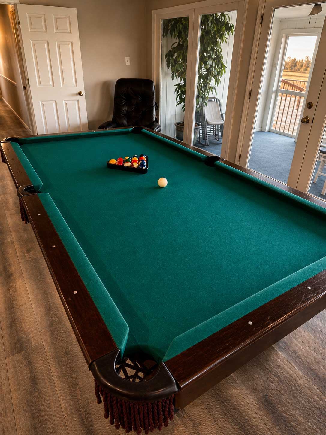Pool table inside Willowood Ranch lodge with natural light and patio access