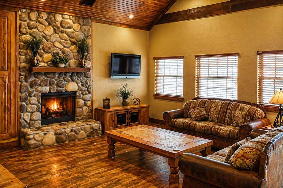 Spacious living room inside Willowood Ranch lodge with leather sofas and warm wood finishes