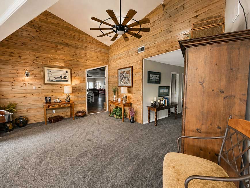 Spacious common area inside Willowood Ranch lodging with vaulted ceilings, wood walls, and seating for wedding guests