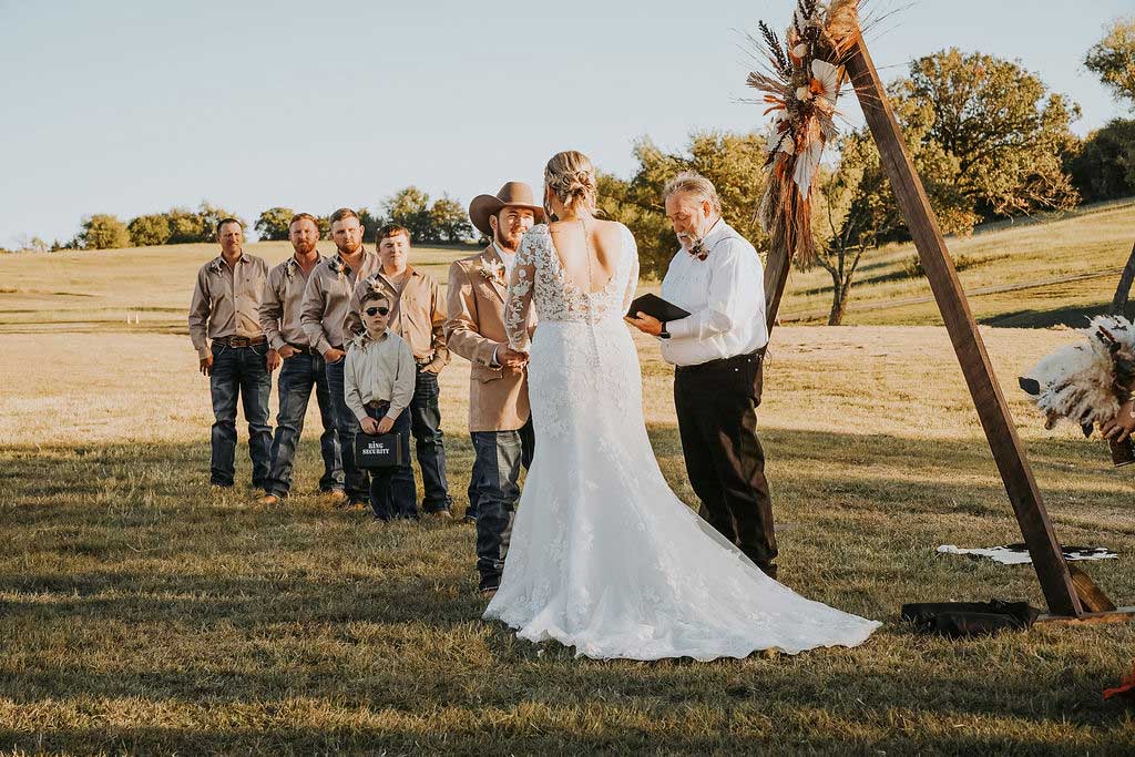 Bride and groom exchanging vows during outdoor country wedding ceremony at Willowood Ranch in North Texas