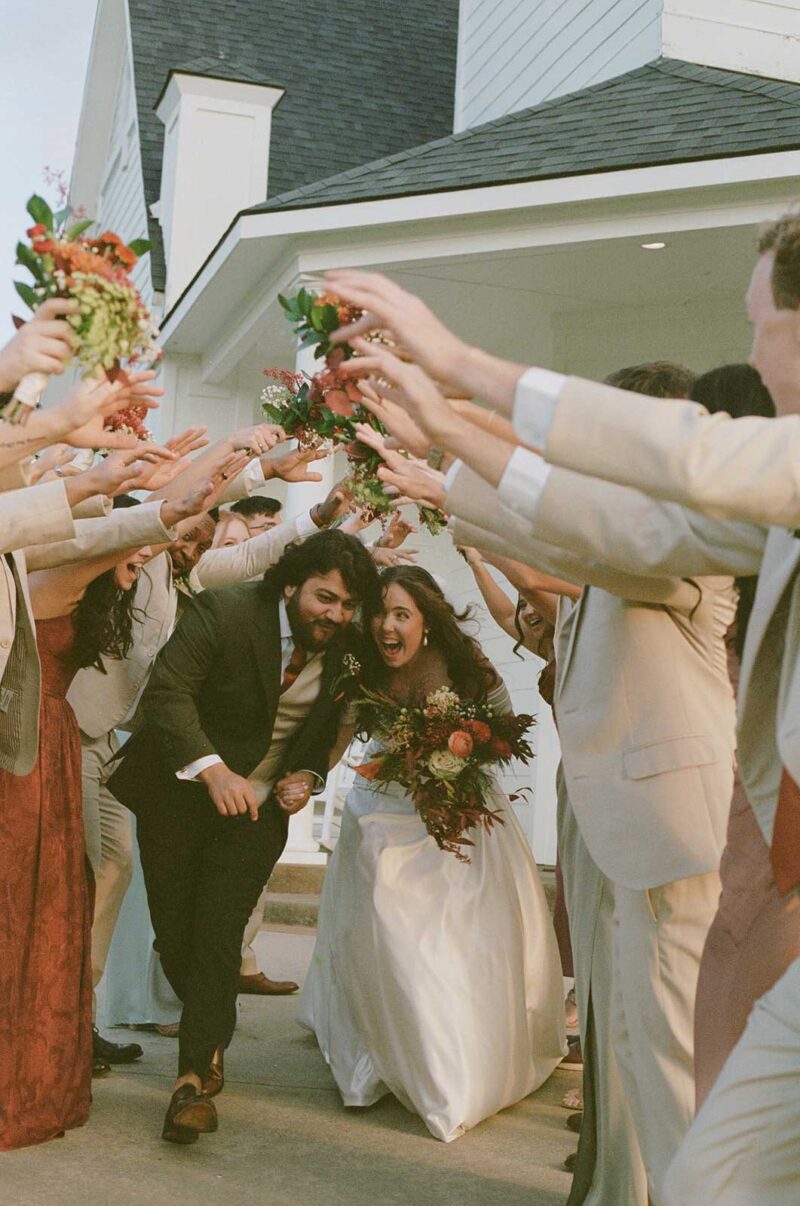 Bride and groom exiting chapel at Willowood Ranch in Bells Texas surrounded by wedding guests celebrating