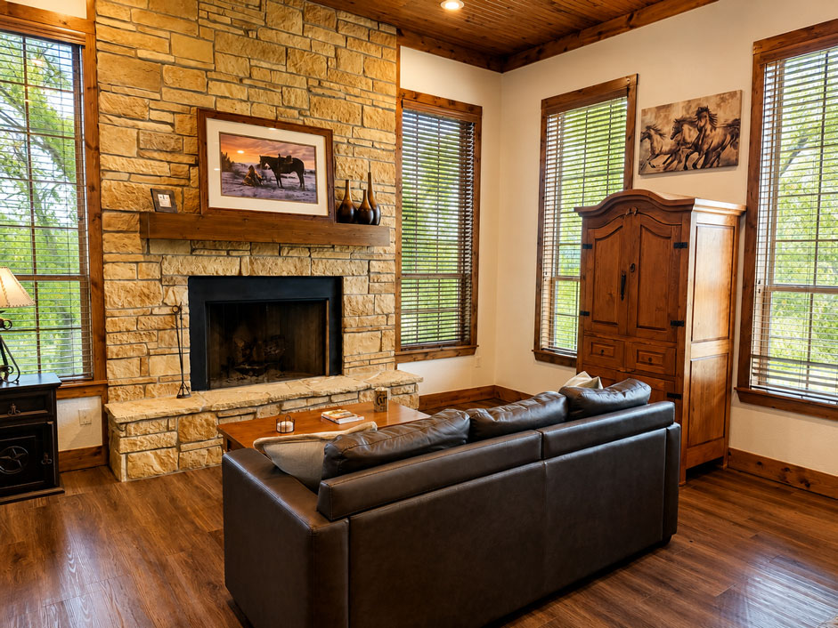 Stone fireplace and cozy seating area inside The Lariat cabin at Willowood Ranch.