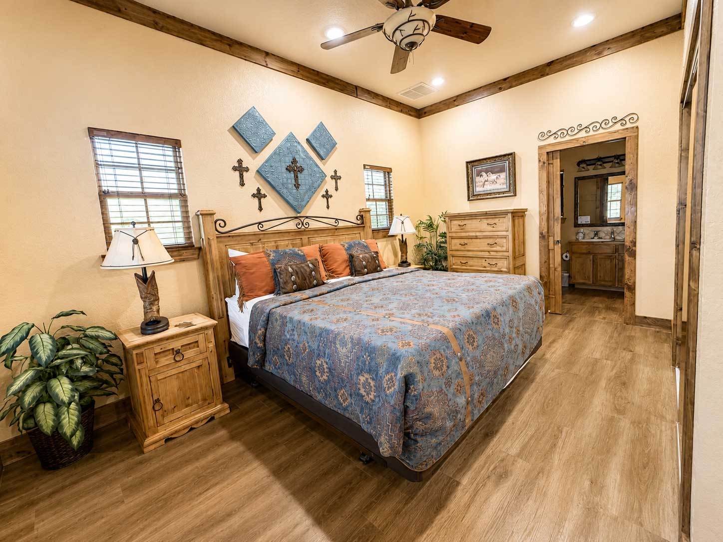 Primary bedroom inside the Lone Star cabin featuring a king bed, rustic wood furnishings, western décor, and private bathroom access.