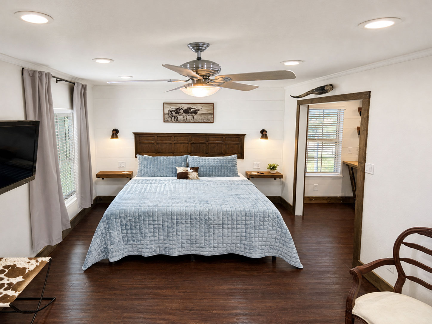 King bedroom inside The Longhorn studio cabin at Willowood Ranch with rustic wood furnishings and comfortable accommodations.
