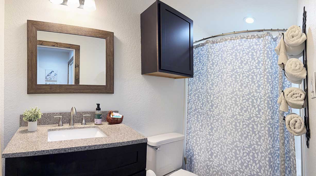 Private bathroom inside The Longhorn studio cabin with full tub and shower, vanity, and fresh towels.